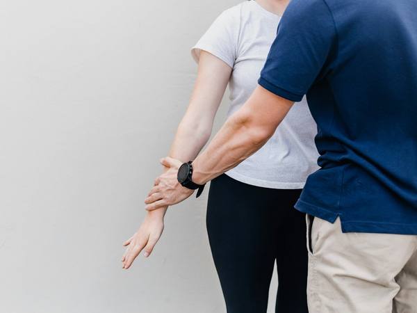 A physiotherapist assessing a patient’s arm movement
