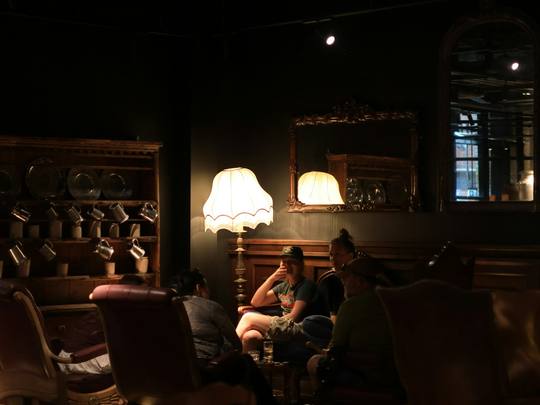 Locals relaxing in a lamp-lit corner of the bar