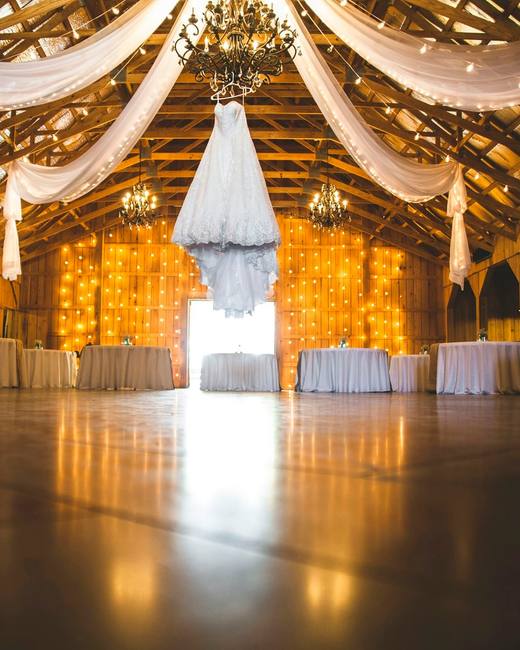 The barn lit up inside with draped fabric and fairy lights