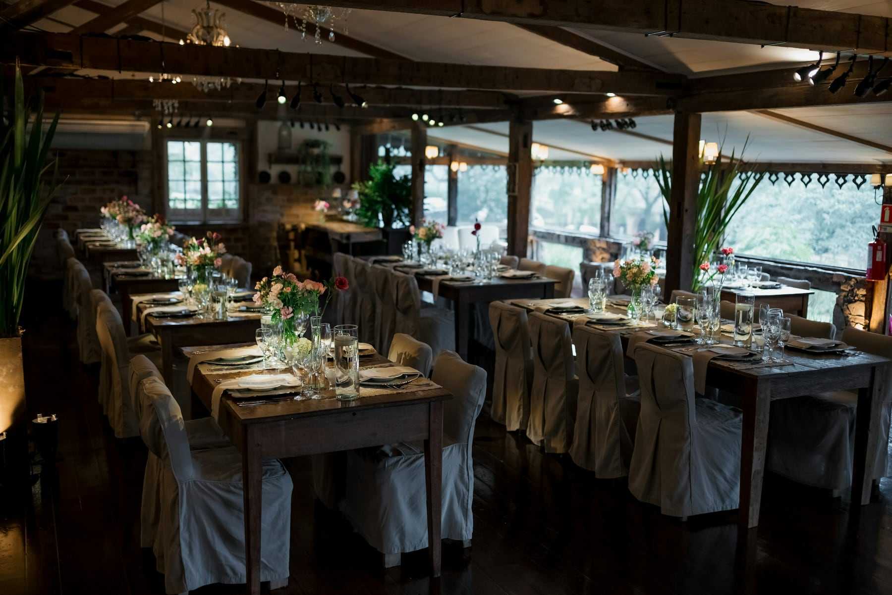 Long tables set for the wedding breakfast in a rustic barn