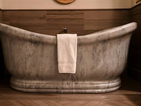A freestanding copper bath with a towel over the side