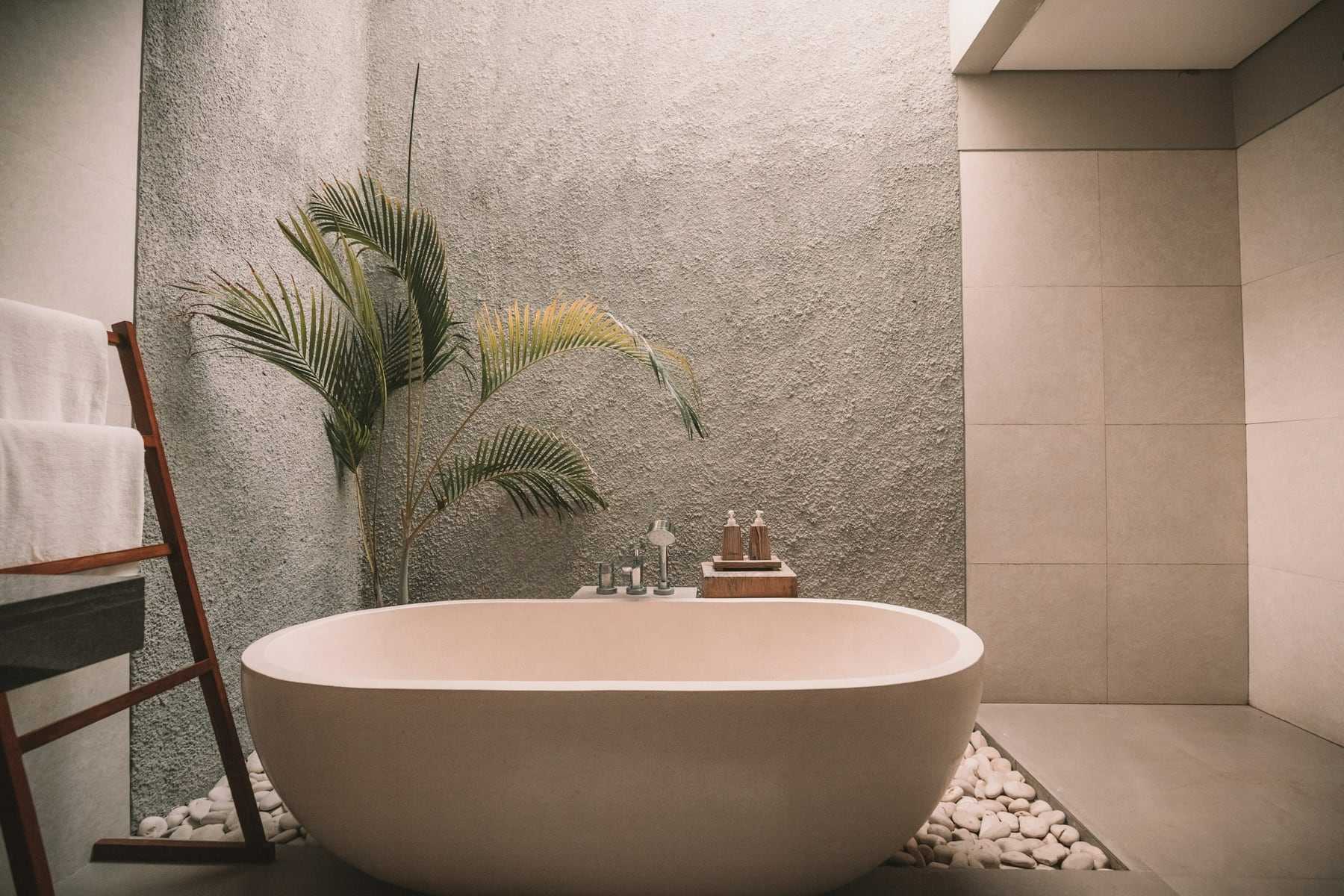 A freestanding bath in a stone-tiled bathroom