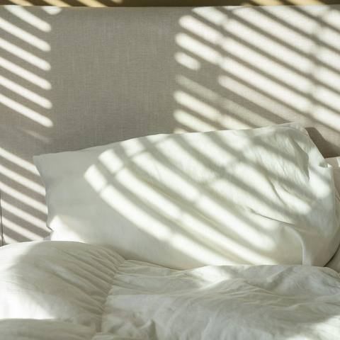Sunlight across a freshly made bed
