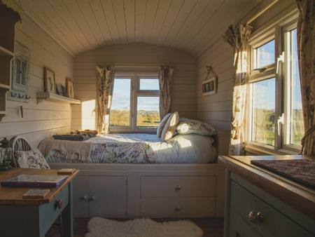 A bedroom with a window seat and built-in cupboards
