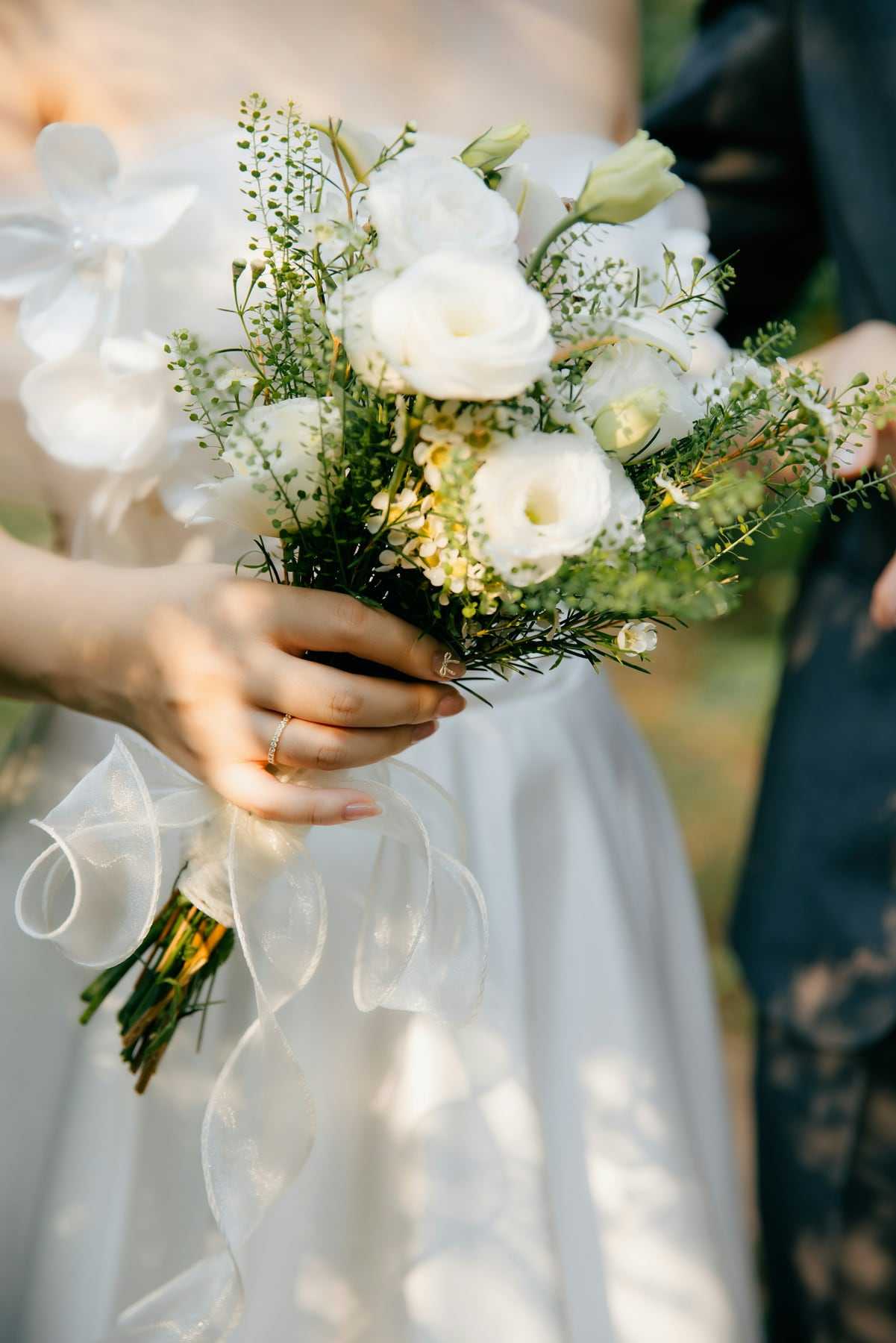 A bride holding her bouquet in warm afternoon sun