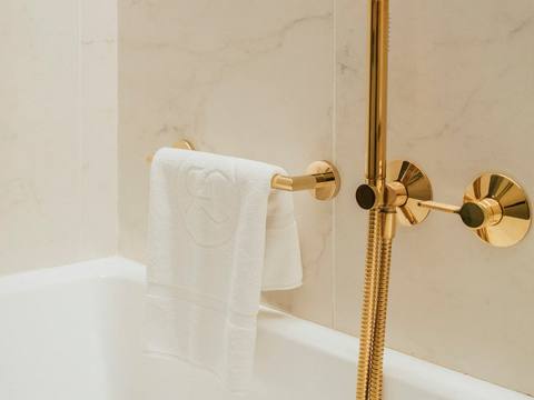Brushed brass shower fittings on a marble wall