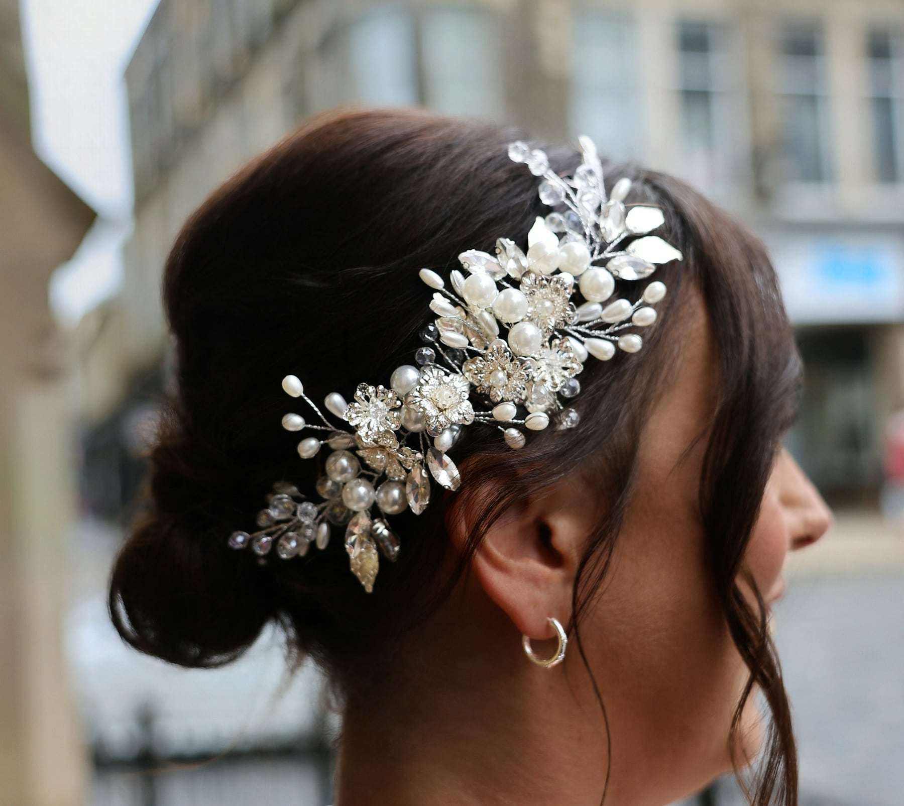 A low chignon finished with a pearl hairpiece