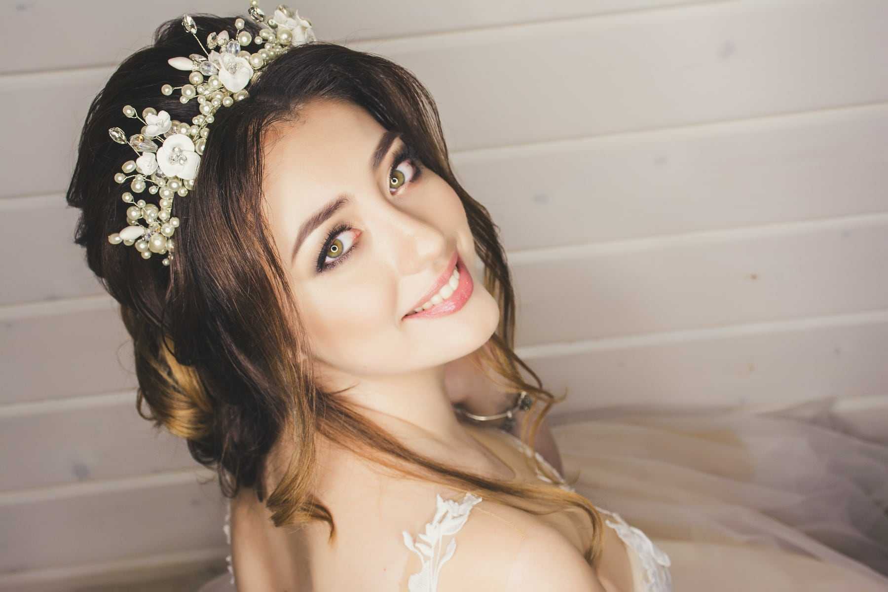 A smiling bride with a floral crown and soft curls