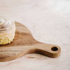 A glazed cardamom bun on a board