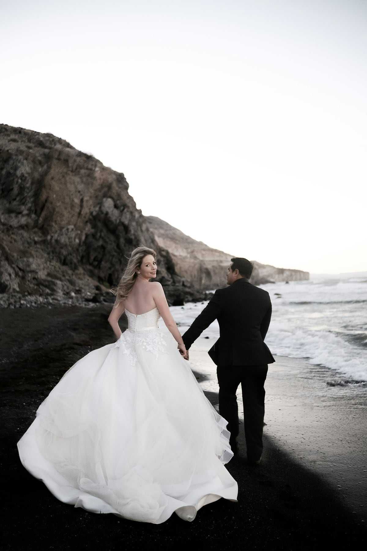 Black and white photo of a couple walking along a beach