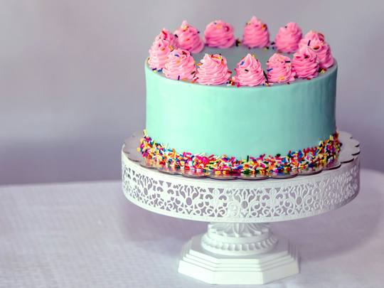 A mint green layer cake with pink buttercream