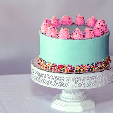 A mint green layer cake with pink buttercream swirls