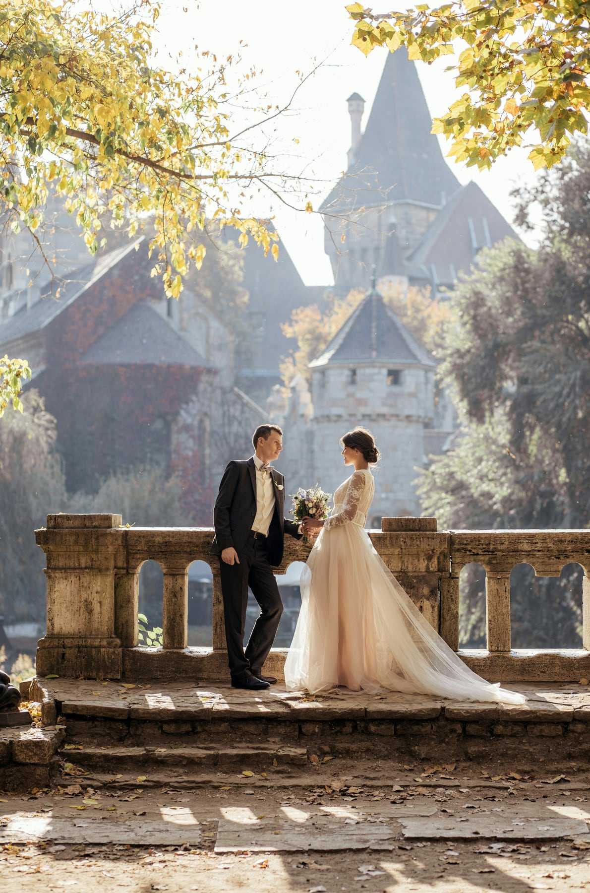A couple on a stone terrace in front of a castle