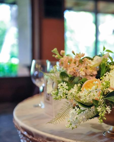 A low centrepiece of peach roses in a copper bowl