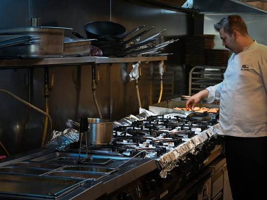 The chef at work at the stove in the pub kitchen