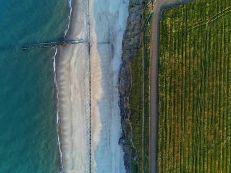 An aerial view of the beach, groynes and fields along the coast