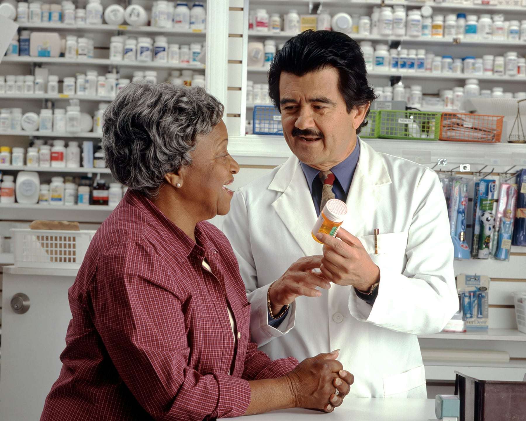 A pharmacist talking to a customer at the counter