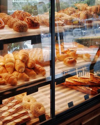A glass counter full of pastries and buns