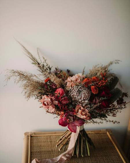 A dried flower bouquet with pampas grass on a stool