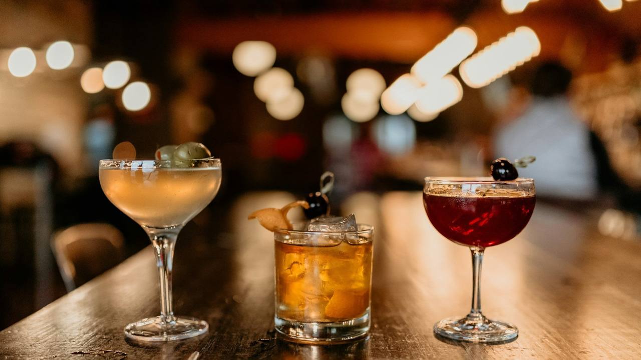 Three cocktails glowing on the bar