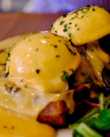 Eggs Benedict with hollandaise and salad leaves