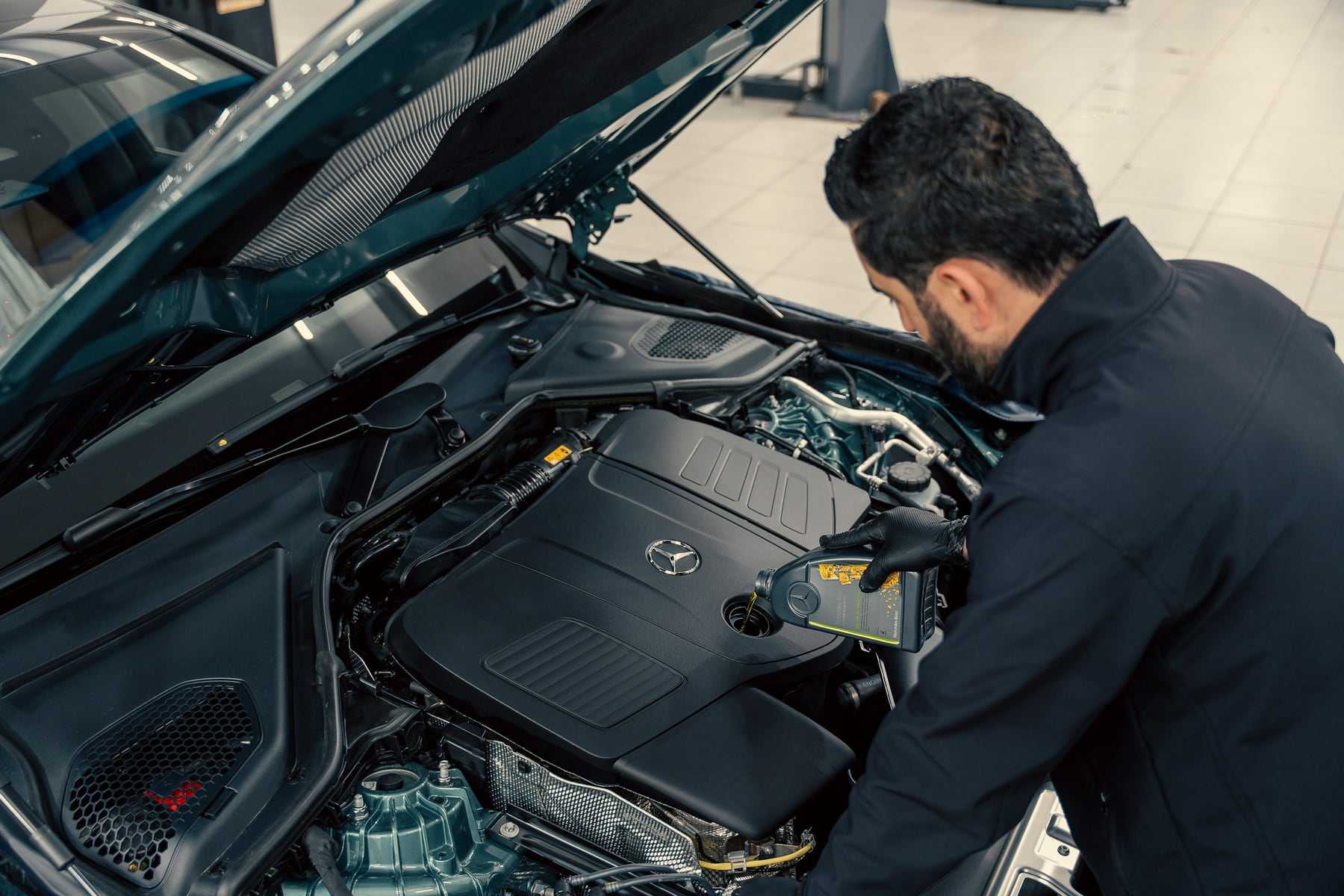 A technician leaning into an open engine bay