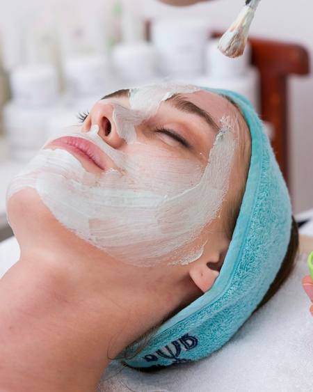 A client relaxing with a face mask during a facial