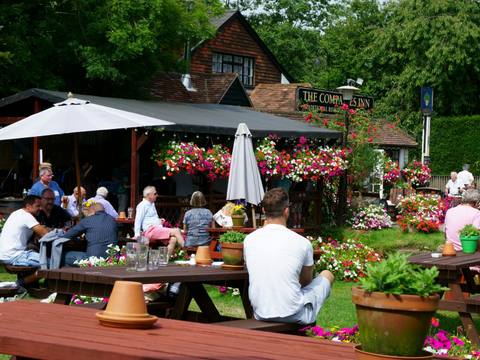People eating at picnic tables in the flower-filled garden