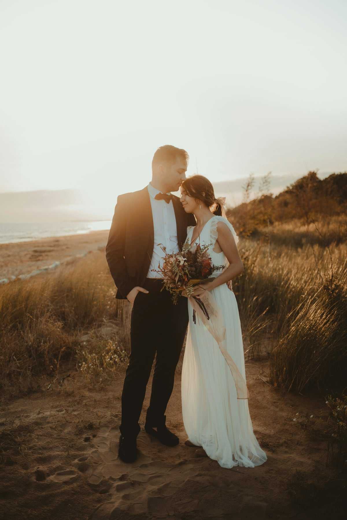 A couple sharing a quiet moment in long golden grass at sunset