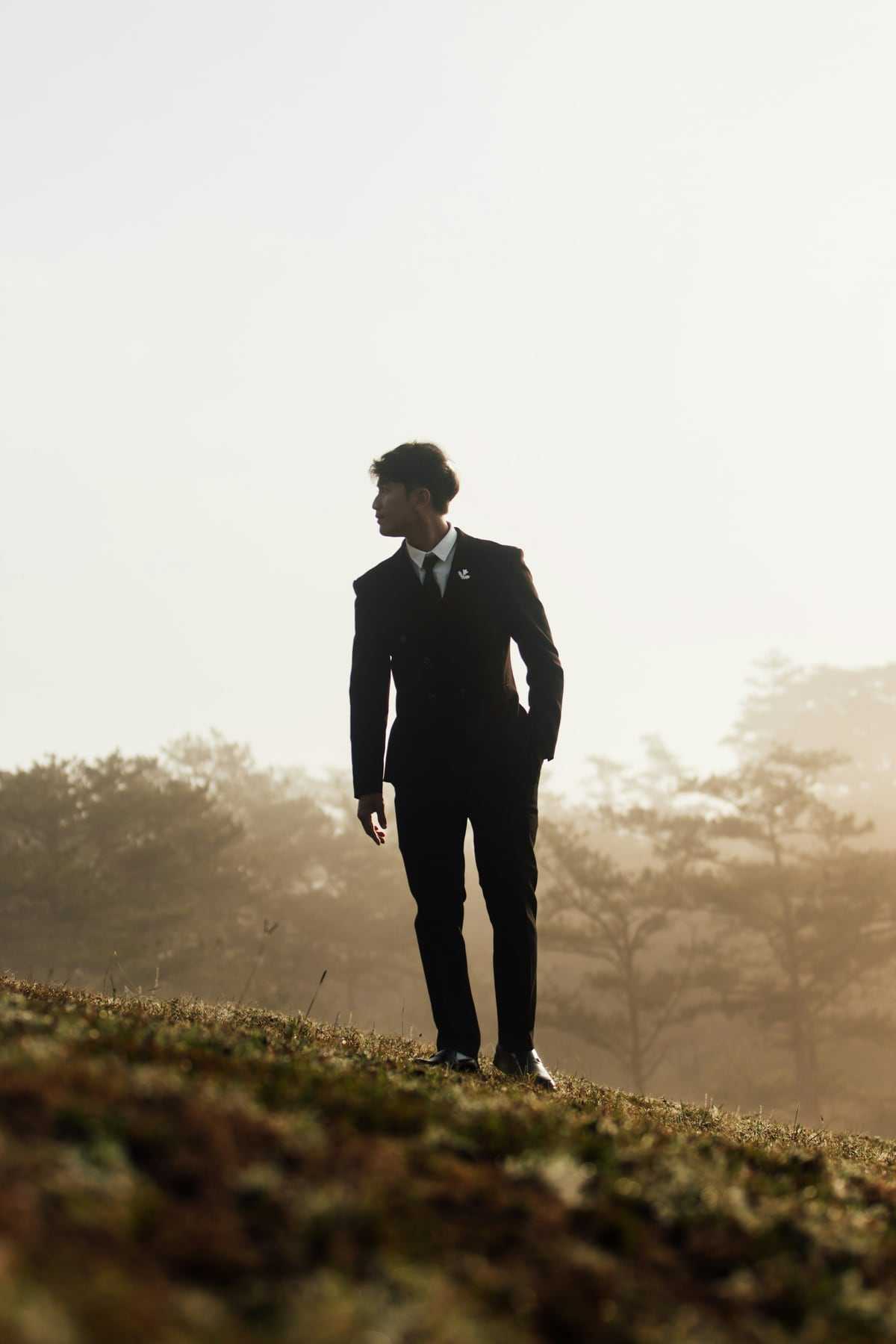 A groom silhouetted on a misty hill