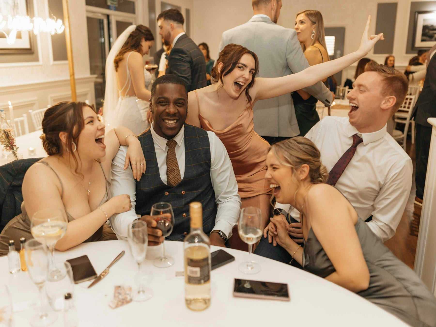 Guests laughing together around a reception table