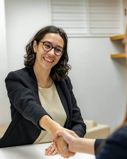 A smiling candidate shaking hands with an interviewer