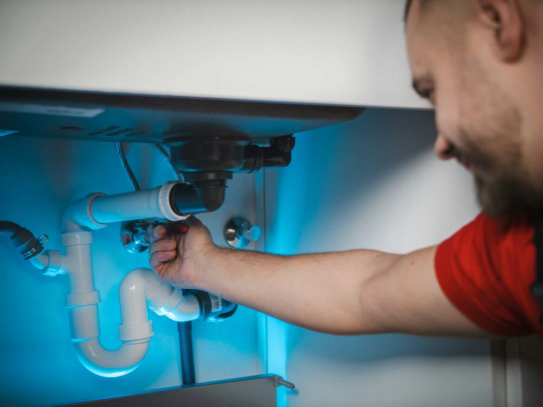 A Tapgrove engineer fixing the pipework under a sink