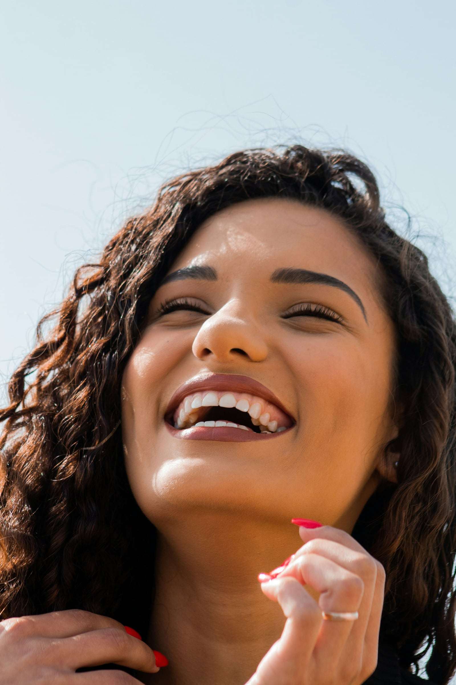A woman laughing with a bright, natural smile