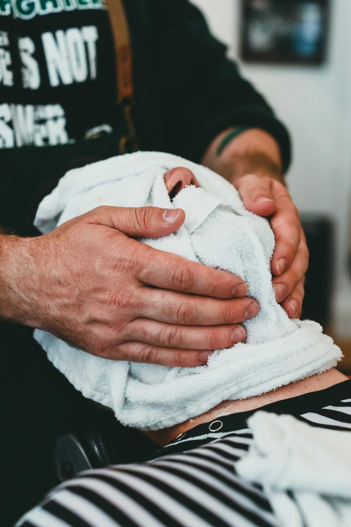 A hot towel wrapped around a client’s face