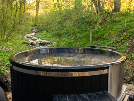 A wood-fired hot tub in a green garden