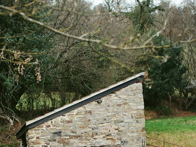 The stone bothy with a wooden hot tub outside