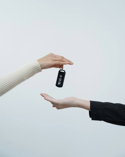 Car keys being passed from one hand to another