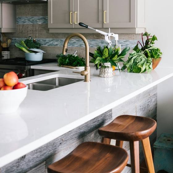 A bright, freshly cleaned kitchen with plants on the worktop