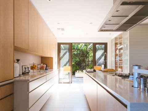 A long galley kitchen leading to garden doors
