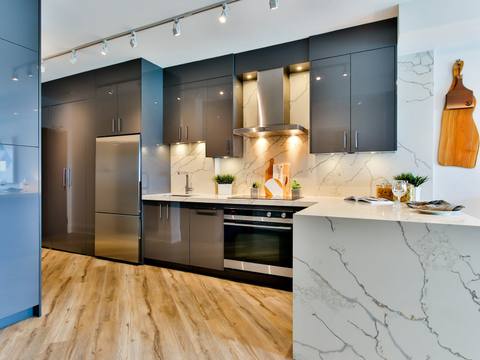 A kitchen with blue cabinets and a marble island