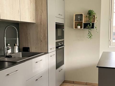 A narrow modern kitchen with a patterned floor