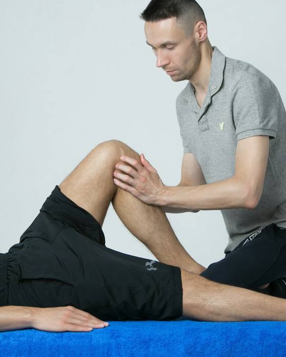 A physiotherapist treating a patient’s knee on a treatment table