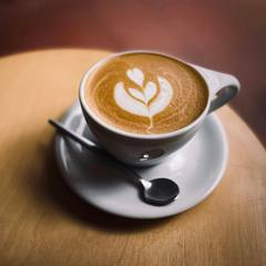 A flat white on a wooden table