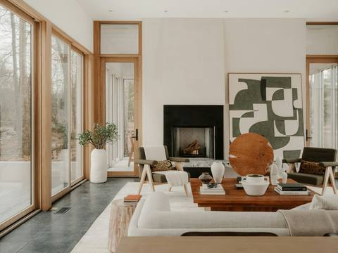 A living room with a modern fireplace and abstract art