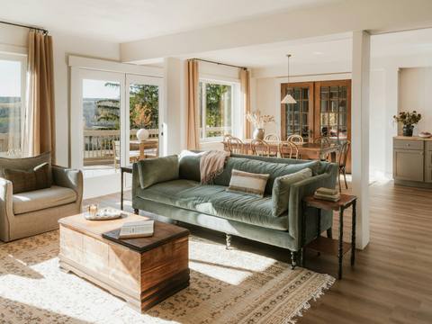 A cosy sitting room with a green sofa and a wooden chest
