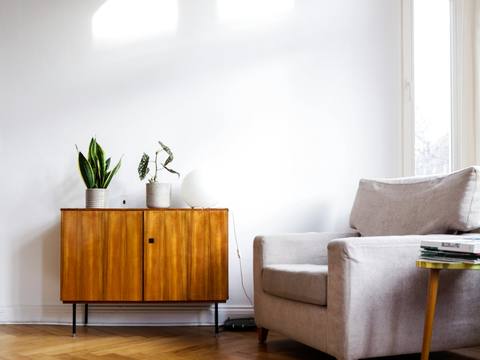 A sitting room with a mid-century sideboard and herringbone floor
