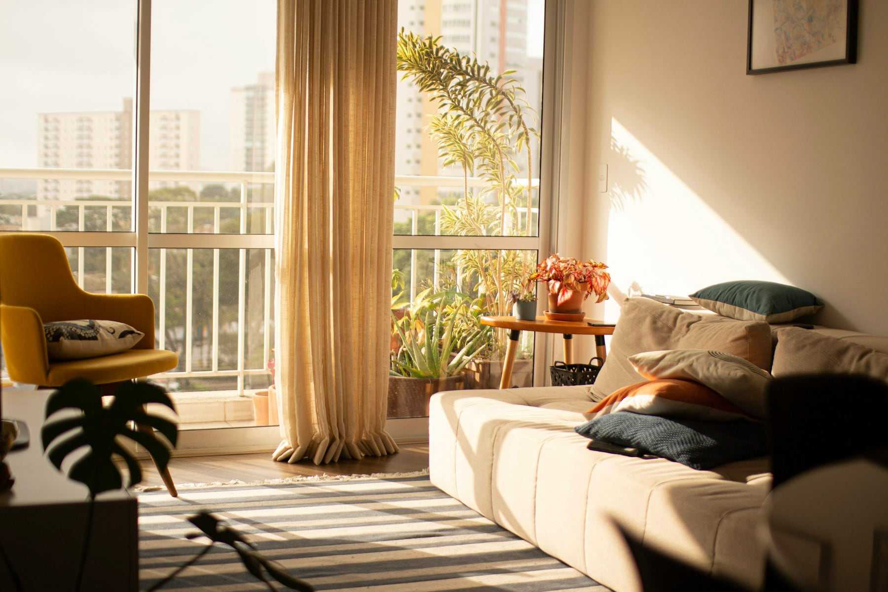 A sunlit harbourside apartment living room with a balcony