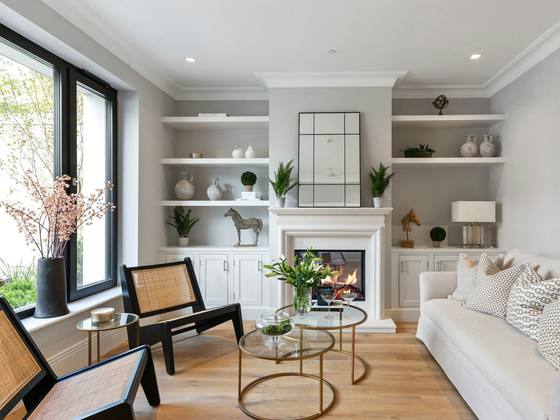 The furnished lounge in a show home with a fireplace and shelving