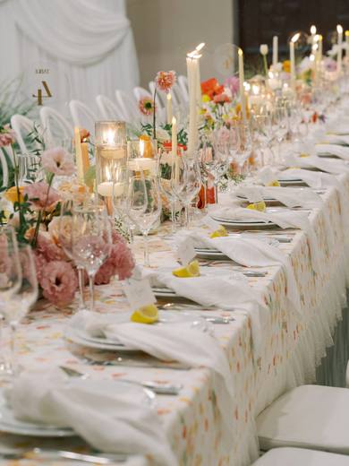 A long candlelit wedding table with flowers down the middle